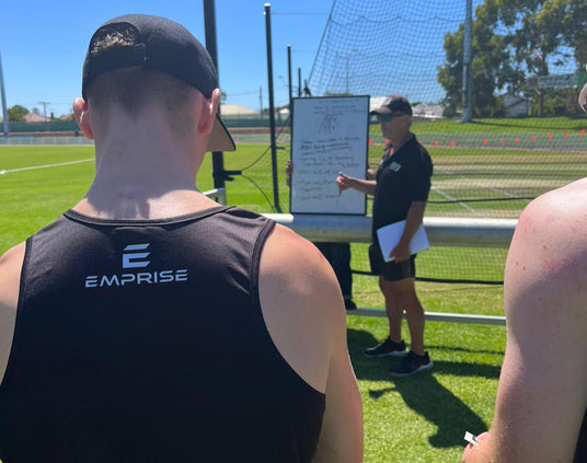 Coach provding feedback to players in an outdoor cricket net