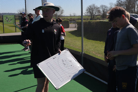 Person holding a whiteboard with a diagram on a sports field