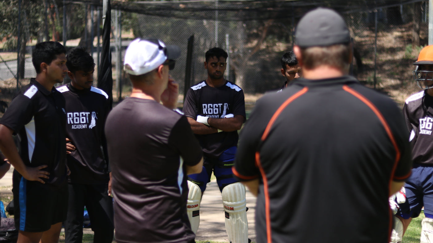 Group of cricket players in a practice session with a coach.