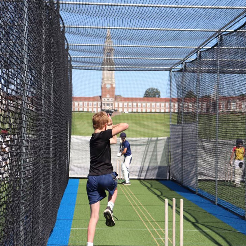 Bowler performing a throw in an outdoor cricket net