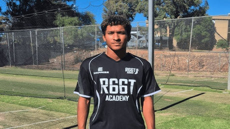 Troy Henry, High Performance Program Gradate, stood wearing a R66T Academy T-Shirt infront of nets