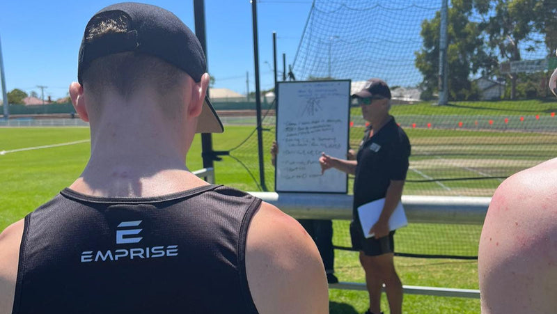 Coach Shaun Seigert provding feedback to players in an outdoor cricket net
