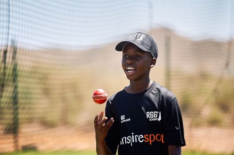 Person holding a cricket ball with a blurred background