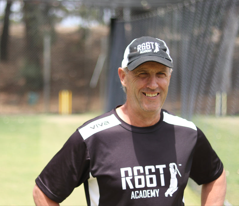 Man wearing a black t-shirt with 'R66T Academy' logo and a cap, standing outdoors.
